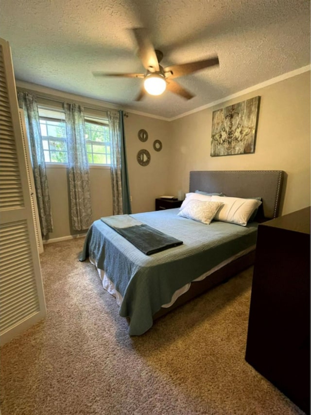 bedroom featuring a textured ceiling, carpet flooring, ornamental molding, and ceiling fan