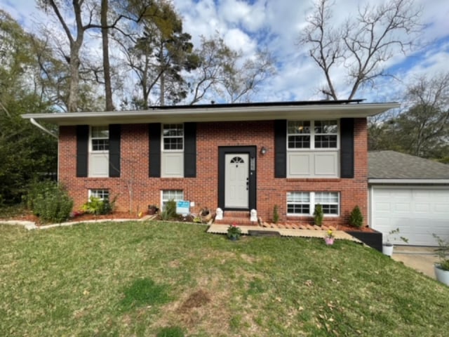 bi-level home with a front lawn and a garage