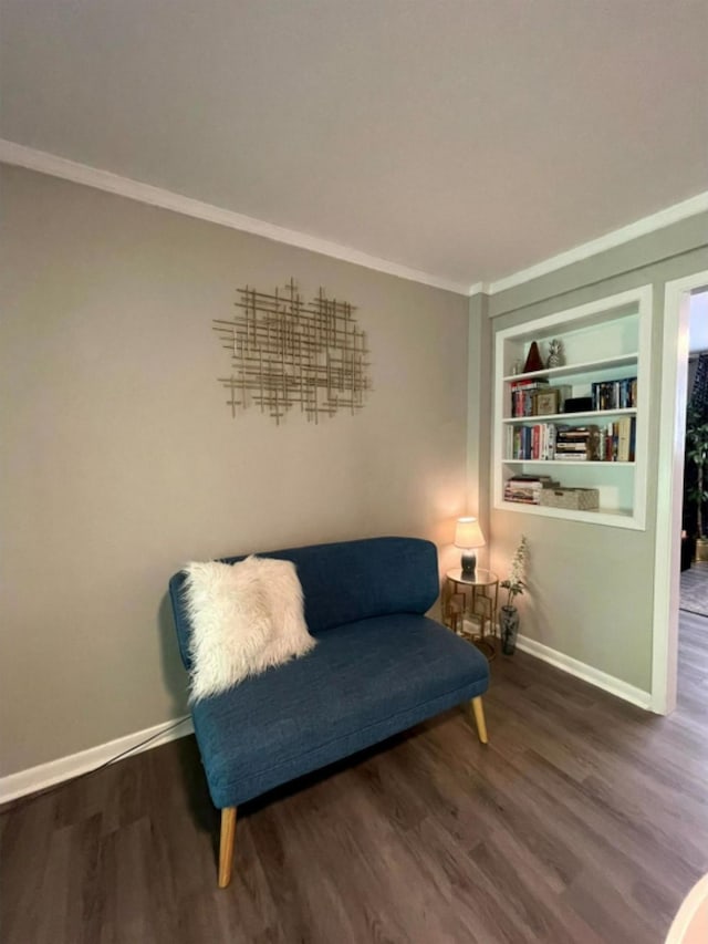 living area featuring hardwood / wood-style floors, built in features, and crown molding