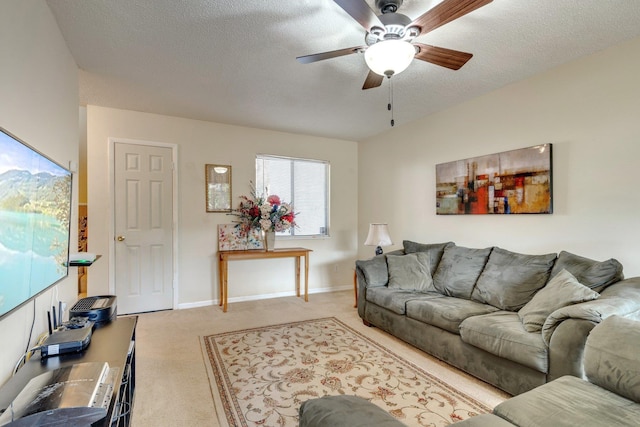 carpeted living room featuring ceiling fan and a textured ceiling