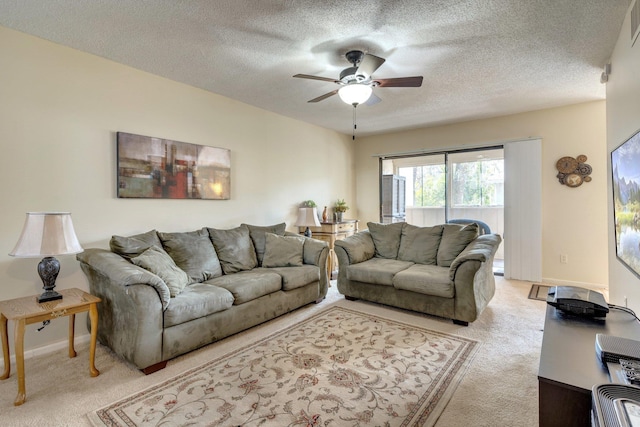 carpeted living room with ceiling fan and a textured ceiling