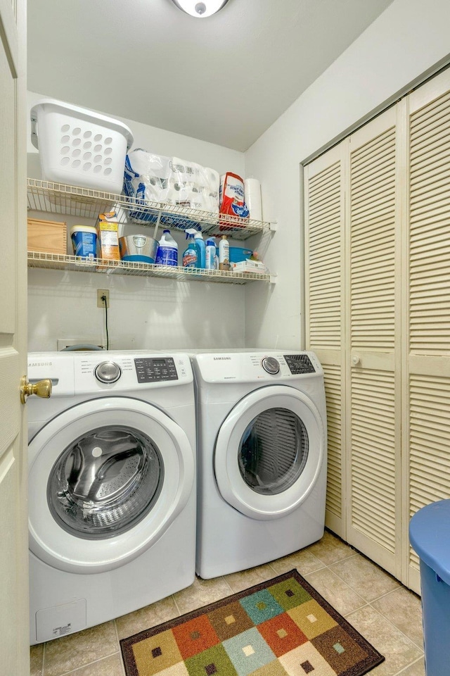 clothes washing area featuring light tile patterned floors and washing machine and clothes dryer