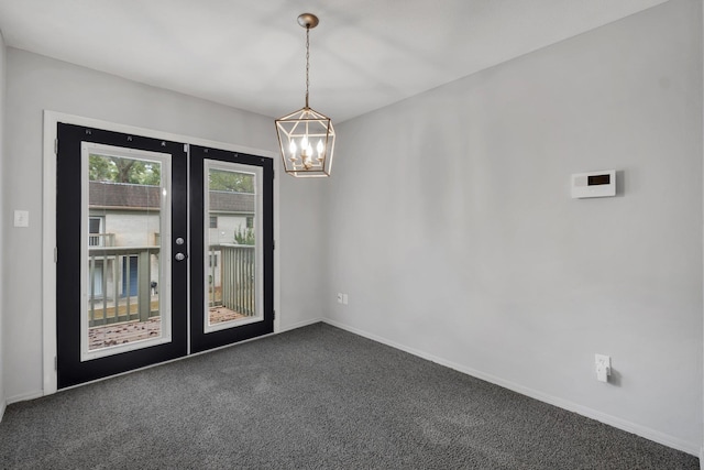 unfurnished room featuring french doors, dark carpet, and a notable chandelier