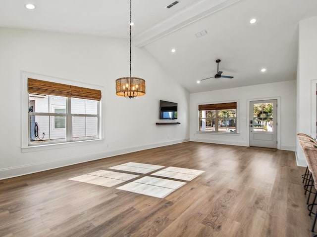 unfurnished living room featuring ceiling fan with notable chandelier, high vaulted ceiling, beam ceiling, and hardwood / wood-style floors