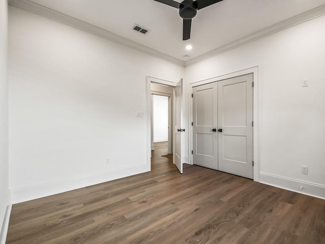 unfurnished bedroom featuring a closet, dark hardwood / wood-style floors, ceiling fan, and ornamental molding