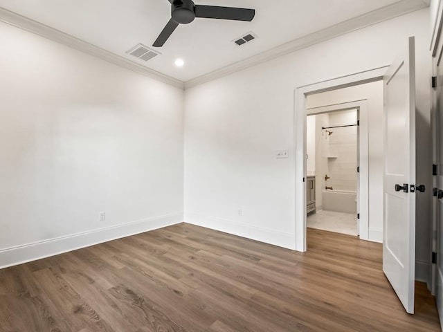 empty room featuring hardwood / wood-style flooring, ornamental molding, and ceiling fan