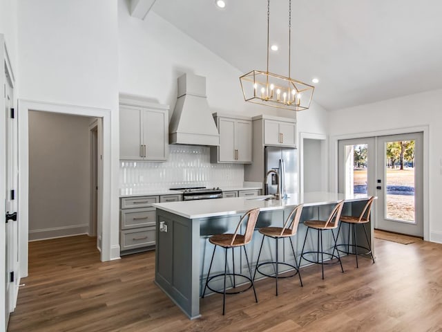 kitchen with premium range hood, a large island, vaulted ceiling with beams, and gray cabinets