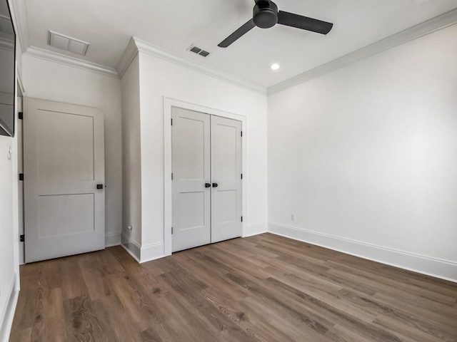 unfurnished bedroom featuring ceiling fan, dark hardwood / wood-style floors, a closet, and crown molding