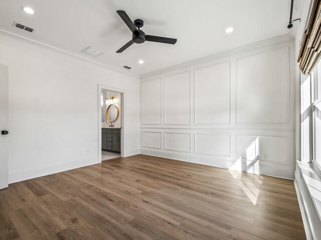 unfurnished bedroom featuring ceiling fan, ornamental molding, hardwood / wood-style floors, and ensuite bath