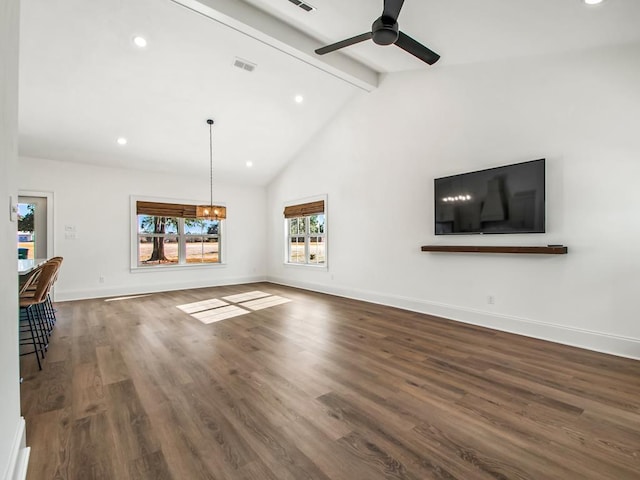 unfurnished living room featuring ceiling fan with notable chandelier, dark hardwood / wood-style flooring, high vaulted ceiling, and beamed ceiling