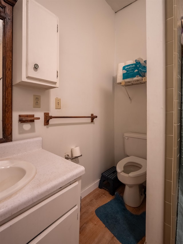 bathroom with hardwood / wood-style flooring, vanity, toilet, and a shower with curtain