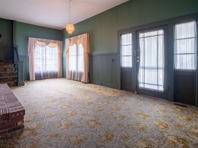 foyer entrance featuring carpet flooring