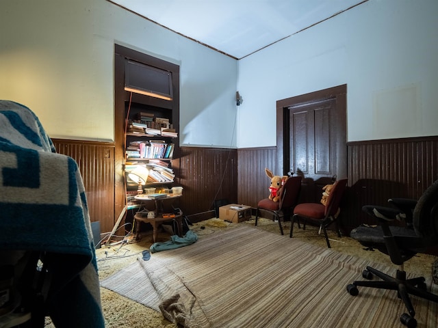 living area featuring carpet floors and wooden walls