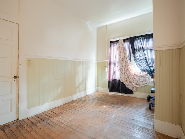 empty room featuring hardwood / wood-style floors and wooden walls