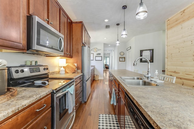 10446 Rose Rd, Tallahassee, FL 32311 - kitchen with light countertops, hardwood / wood-style floors, stainless steel appliances, hanging light fixtures, and a sink