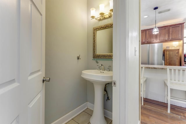 10446 Rose Rd, Tallahassee, FL 32311 - bathroom with baseboards, visible vents, a sink, and wood finished floors