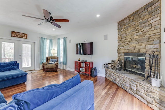 10446 Rose Rd, Tallahassee, FL 32311 - living room featuring a stone fireplace, wood finished floors, ceiling fan, and french doors