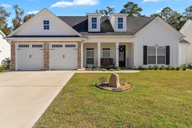 view of front of house featuring a garage, covered porch, and a front lawn