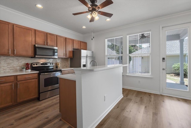 4312 Four Oaks Blvd, Tallahassee, FL 32311 - kitchen featuring stainless steel appliances, tasteful backsplash, brown cabinets, plenty of natural light, and ornamental molding