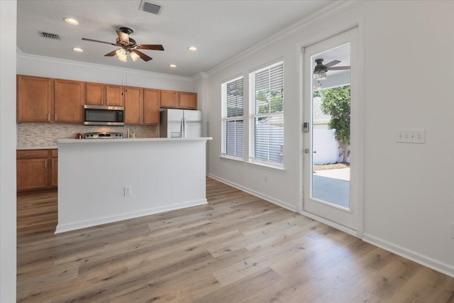 4312 Four Oaks Blvd, Tallahassee, FL 32311 - kitchen with ceiling fan, brown cabinetry, crown molding, fridge with ice dispenser, and stainless steel microwave