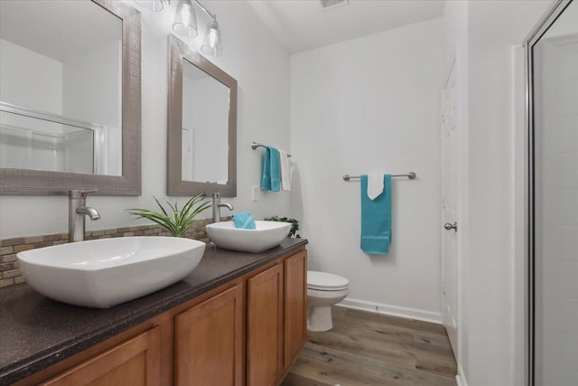 4312 Four Oaks Blvd, Tallahassee, FL 32311 - full bathroom with wood finished floors, decorative backsplash, double vanity, and a shower with shower door