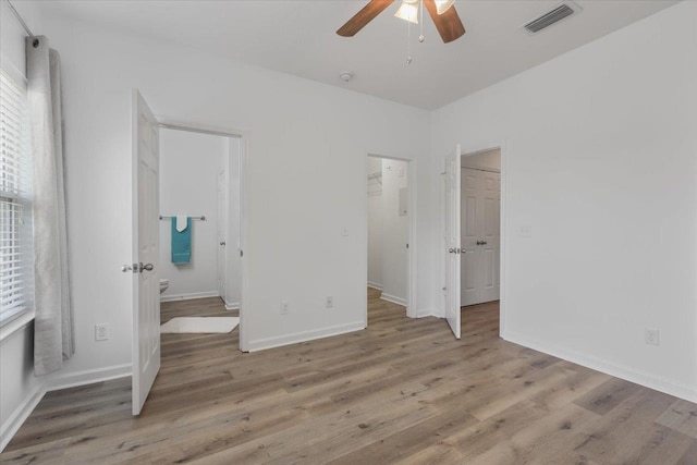 4312 Four Oaks Blvd, Tallahassee, FL 32311 - unfurnished bedroom with wood finished floors, ensuite bath, a spacious closet, and a ceiling fan