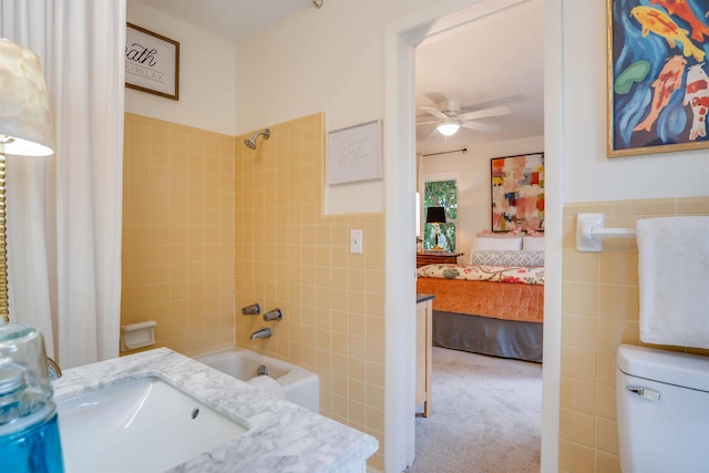 full bathroom featuring sink, tile walls, ceiling fan, toilet, and shower / bath combo