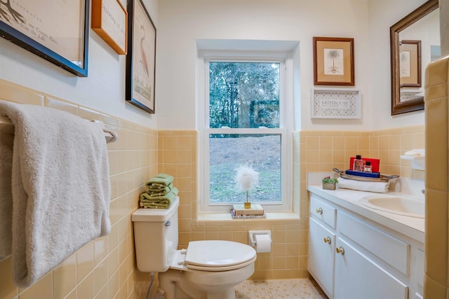 bathroom with vanity, plenty of natural light, tile walls, and toilet