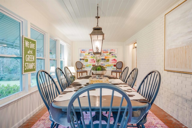 dining area with wood ceiling and brick wall