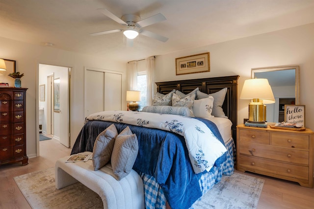 bedroom with ceiling fan, a closet, ensuite bathroom, and light hardwood / wood-style flooring