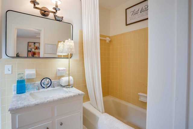 bathroom featuring tile walls, vanity, decorative backsplash, and shower / tub combo with curtain