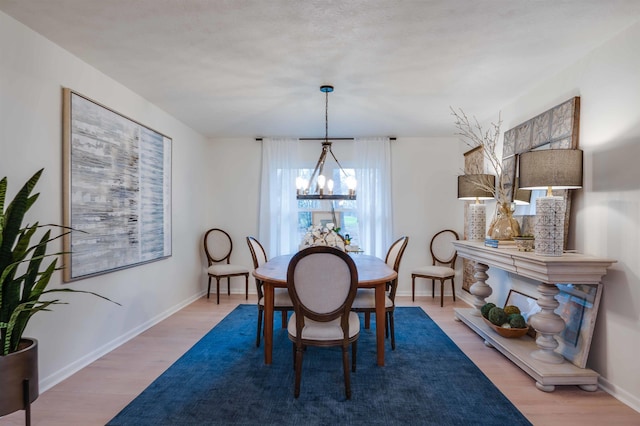 dining area with a chandelier and light hardwood / wood-style flooring