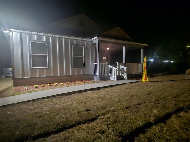 view of front of home featuring covered porch and a yard