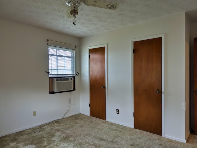 unfurnished bedroom with light colored carpet, a textured ceiling, and cooling unit