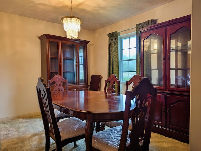 carpeted dining room with a chandelier and a textured ceiling