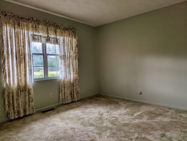 empty room featuring a textured ceiling and light carpet