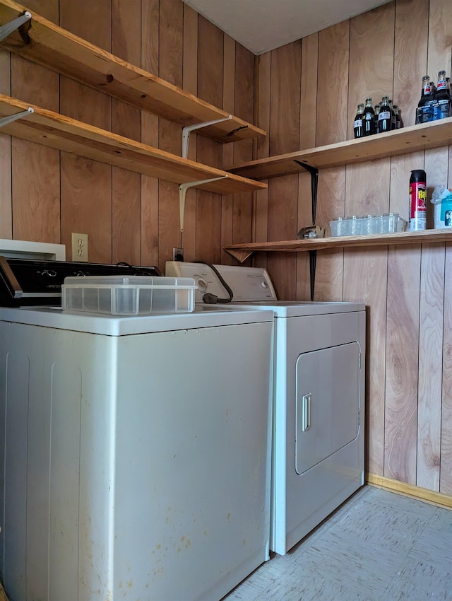 washroom featuring wood walls and independent washer and dryer