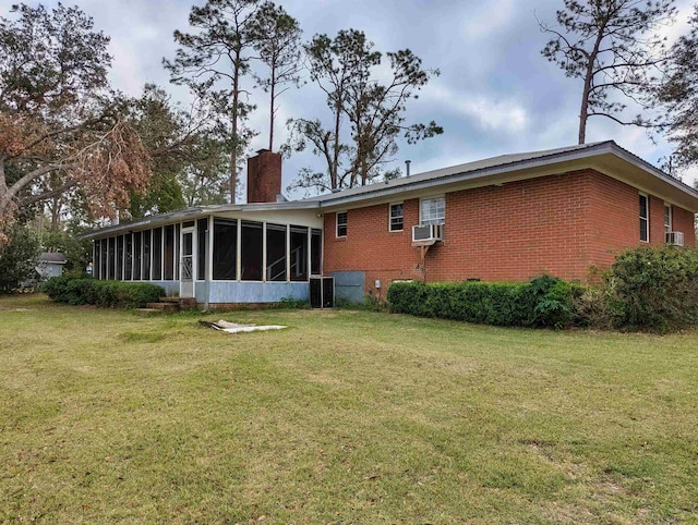 rear view of property featuring a lawn, a sunroom, and cooling unit