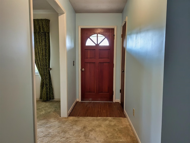 doorway to outside featuring a textured ceiling and carpet floors