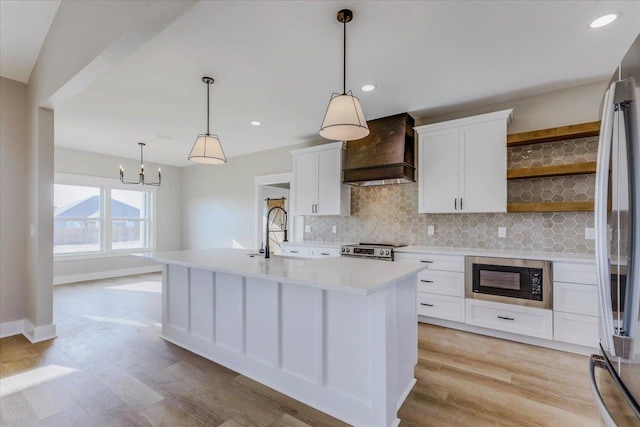 kitchen with white cabinetry, sink, custom exhaust hood, and stainless steel appliances