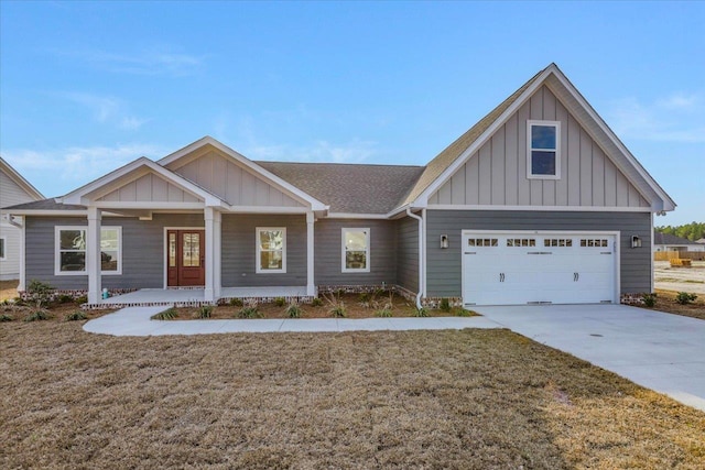 craftsman-style home with a garage, covered porch, and a front lawn