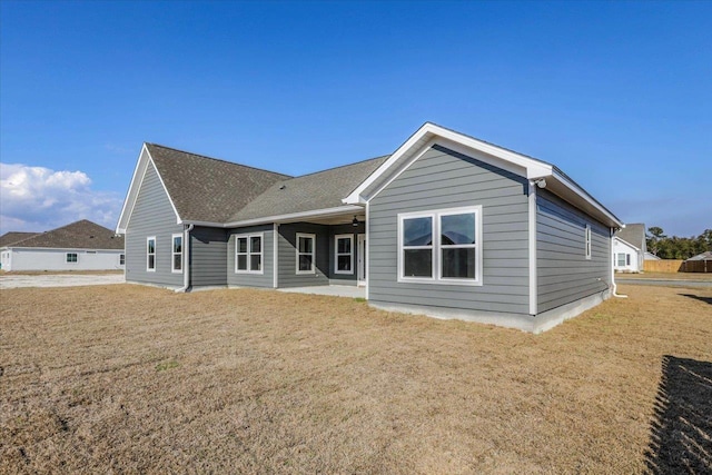 rear view of house featuring a lawn