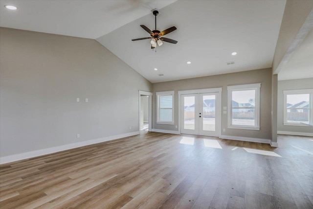 unfurnished living room featuring ceiling fan, high vaulted ceiling, light wood-type flooring, and french doors