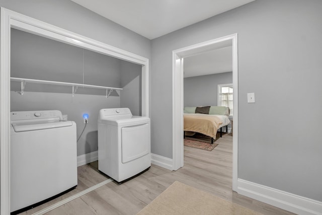 laundry room featuring light wood-type flooring and washing machine and clothes dryer