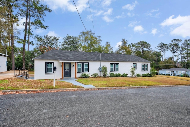 ranch-style home featuring a front yard