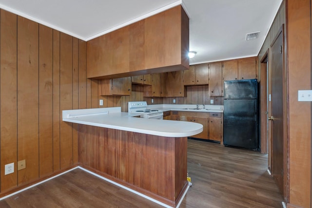 kitchen featuring kitchen peninsula, dark hardwood / wood-style flooring, black fridge, sink, and white electric range
