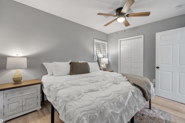 bedroom featuring a closet, light hardwood / wood-style flooring, and ceiling fan
