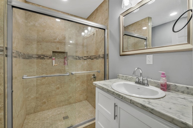 bathroom with vanity and a shower with door