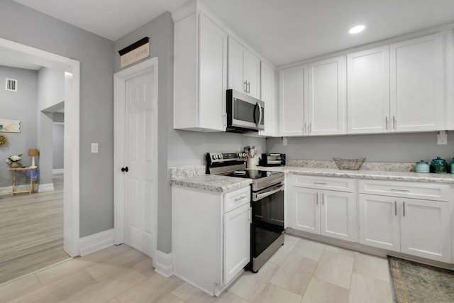 kitchen featuring light stone countertops, white cabinetry, and appliances with stainless steel finishes