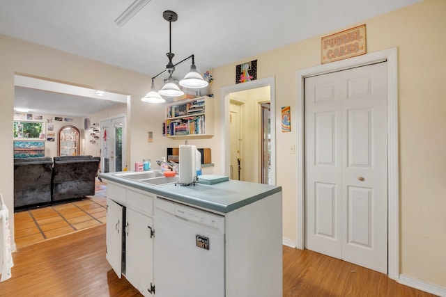 kitchen with white cabinetry, hanging light fixtures, a kitchen island, light wood-type flooring, and dishwasher